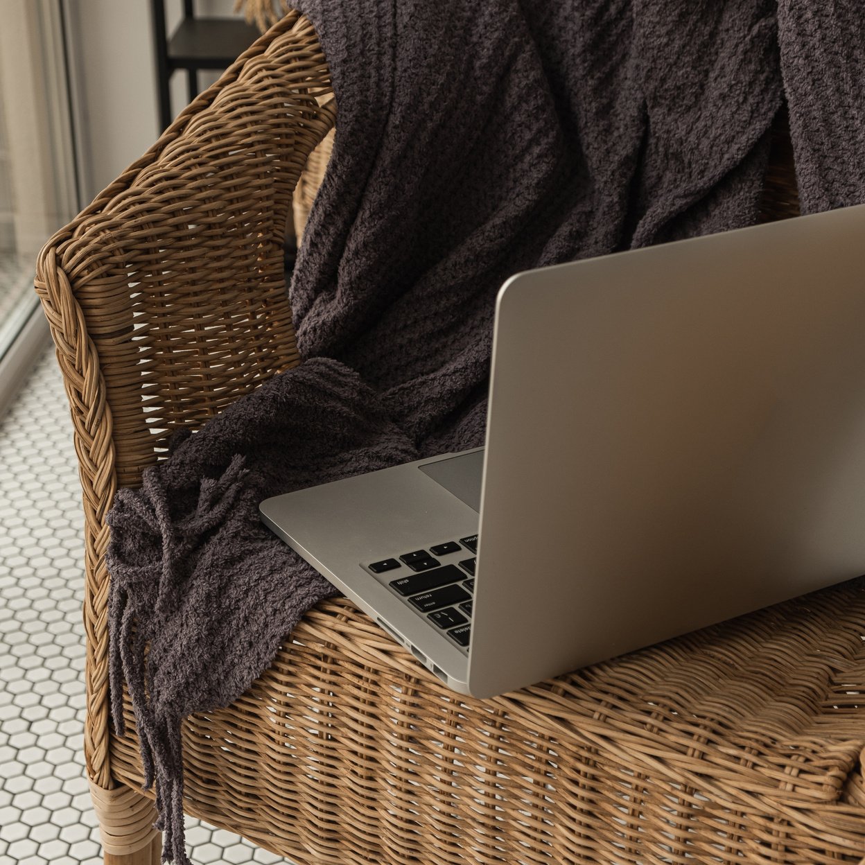 Laptop on a Rattan Chair with Knitted Fabric